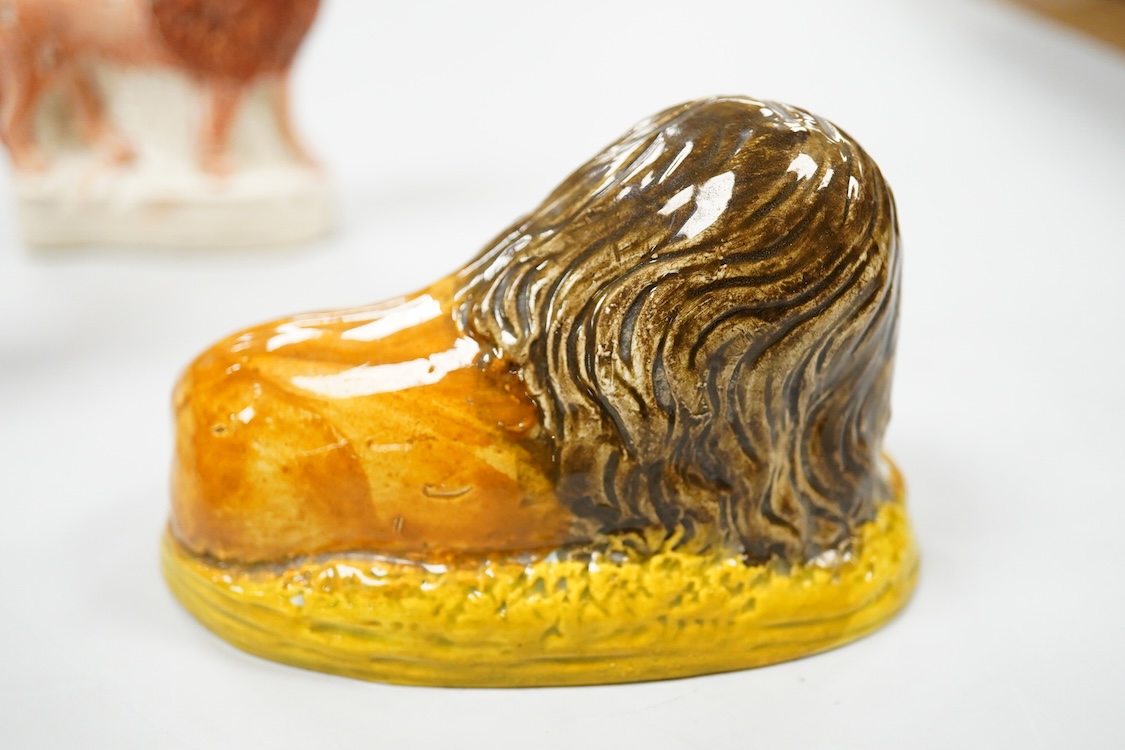 A rare Staffordshire Pearlware model of a recumbent lion, c.1810, and three Staffordshire pottery models of lions, mid 19th century, largest 11cm wide
